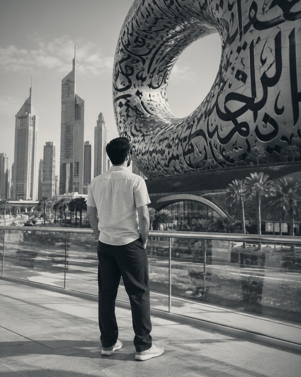 Yaman Wazzan on a walkway in Dubai, looking out toward the Museum of the Future and the Sheikh Zayed Road towers